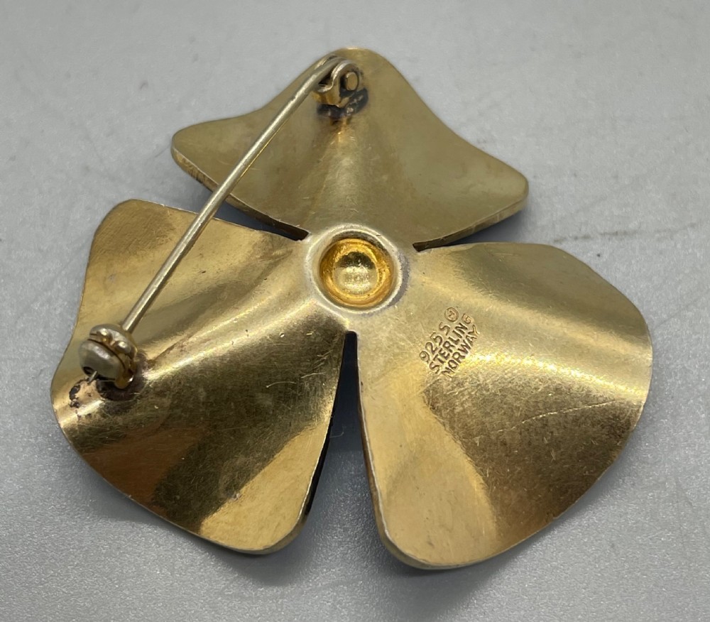 A vintage Norwegian three-petaled flower brooch crafted in gold-plated sterling silver featuring vibrant cobalt blue guilloche enamel. View V
