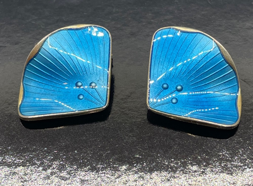 A pair of mid-century Norwegian fan-shaped clip-on earrings rendered in silver gilt with bright blue guilloche enamel, ribbed lines, and small dot accents. View VI