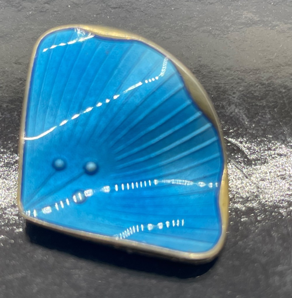 A pair of mid-century Norwegian fan-shaped clip-on earrings rendered in silver gilt with bright blue guilloche enamel, ribbed lines, and small dot accents. View VII