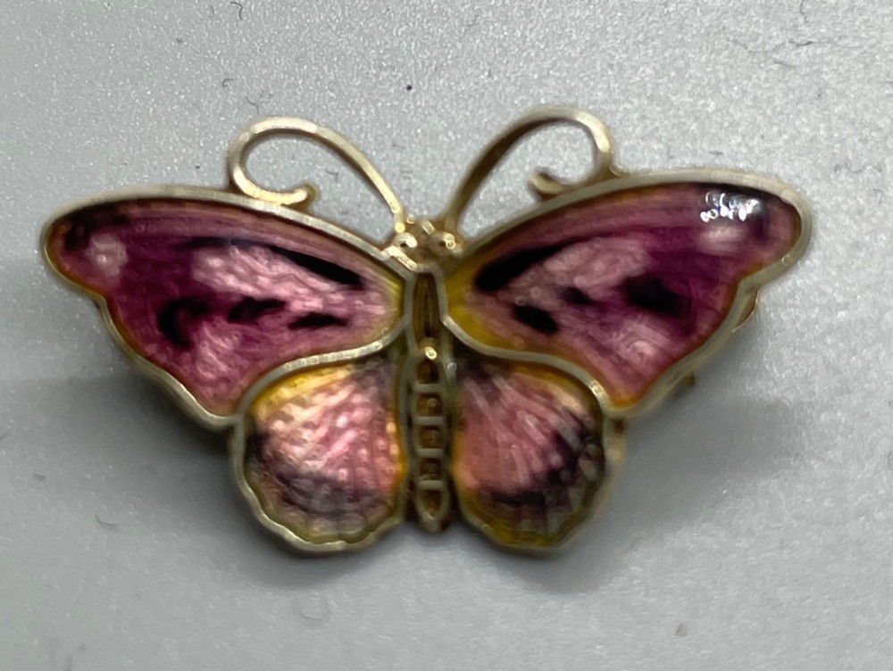 A small butterfly-shaped silver gilt brooch decorated with pink and yellow translucent guilloche enamel. View II