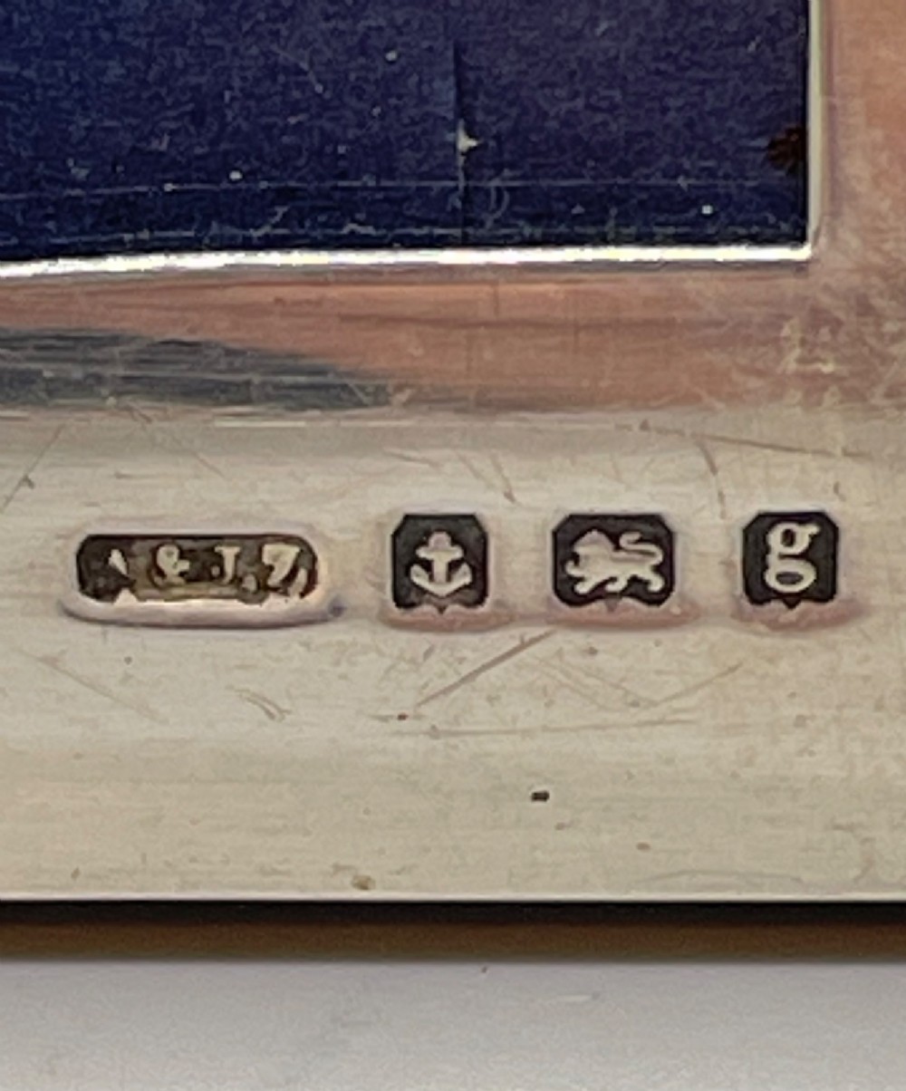An Edwardian sterling silver rectangular photo frame featuring a plain polished border with visible English silver hallmarks at the base. View VIII