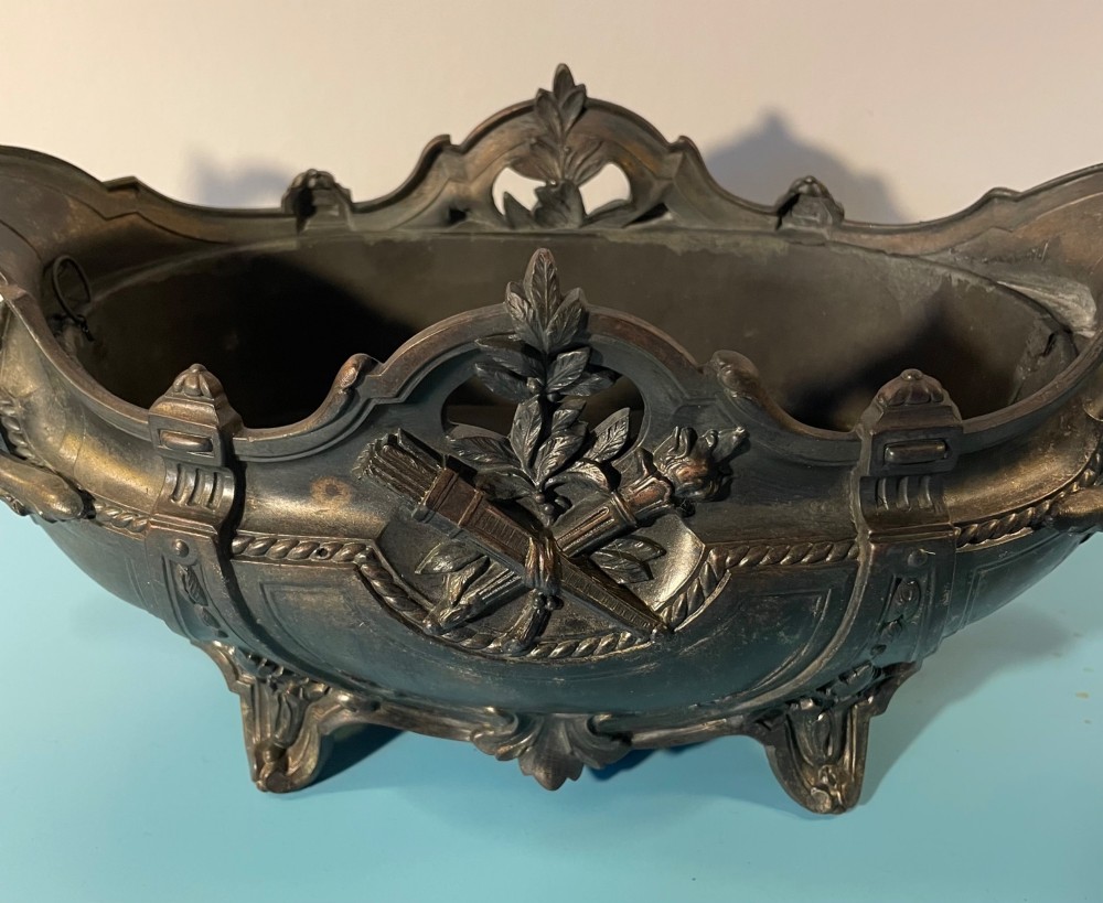 An ornate late 19th-century dark French cast metal jardiniere featuring foliage scrolls, twin handles, and central torch motifs. View V