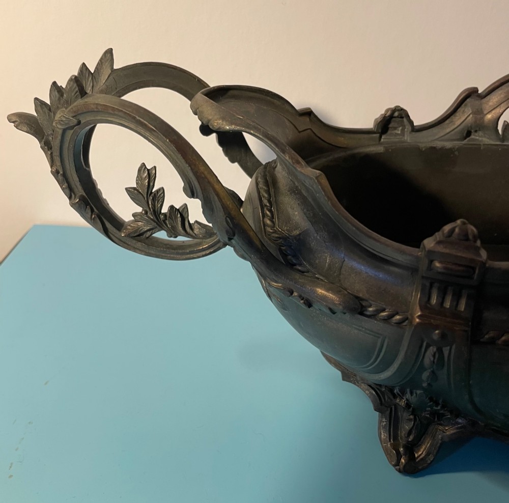 An ornate late 19th-century dark French cast metal jardiniere featuring foliage scrolls, twin handles, and central torch motifs. View VII