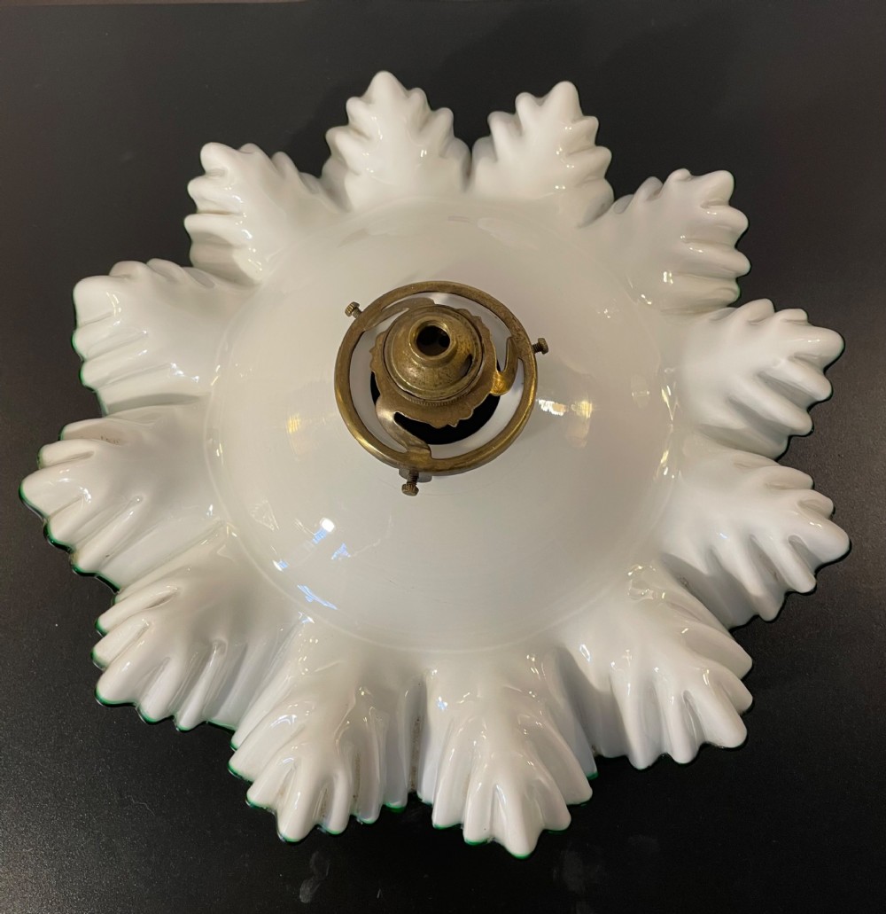A white opaline glass lampshade with a fluted frilled edge trimmed in green glass, mounted with a brass top fixture. View II