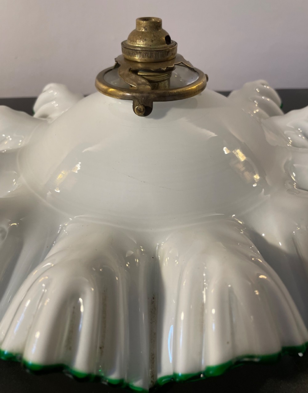 A white opaline glass lampshade with a fluted frilled edge trimmed in green glass, mounted with a brass top fixture. View III