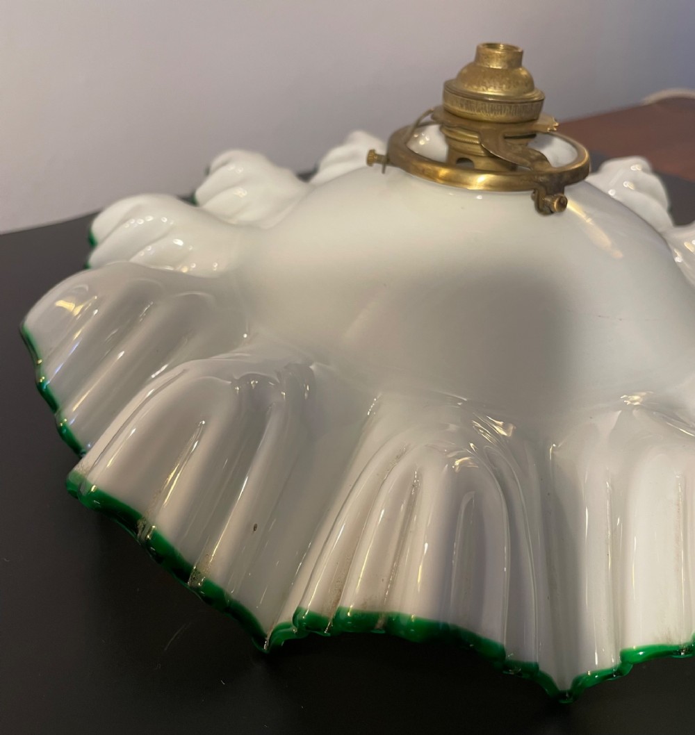A white opaline glass lampshade with a fluted frilled edge trimmed in green glass, mounted with a brass top fixture. View IV