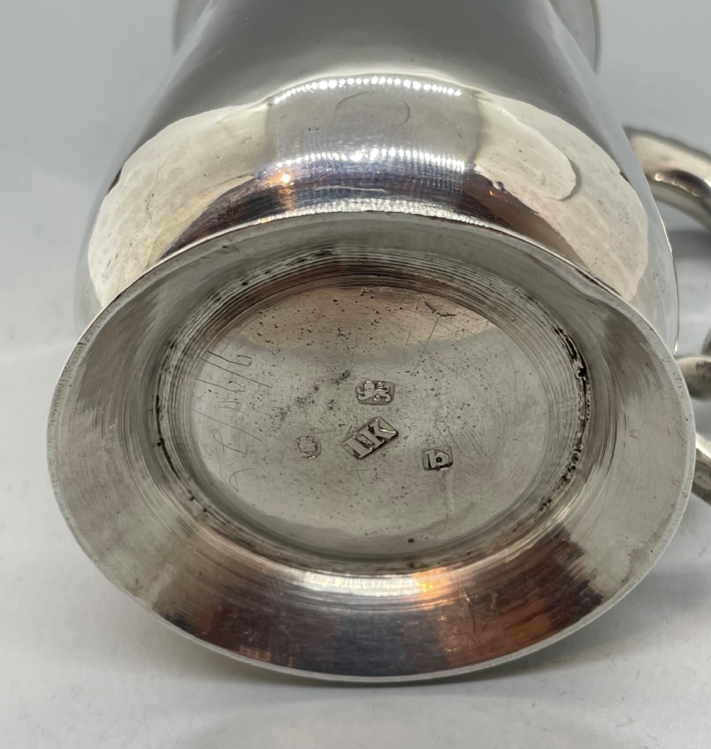 A Georgian sterling silver baluster-shaped mug featuring a leaf-capped double-scroll handle and a stepped circular base. View VIII