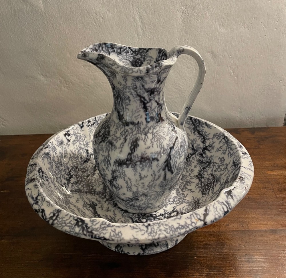 An early nineteenth-century Staffordshire flow blue ceramic wash set comprising a flared jug and matching wide wash basin with a mottled blue pattern. View II