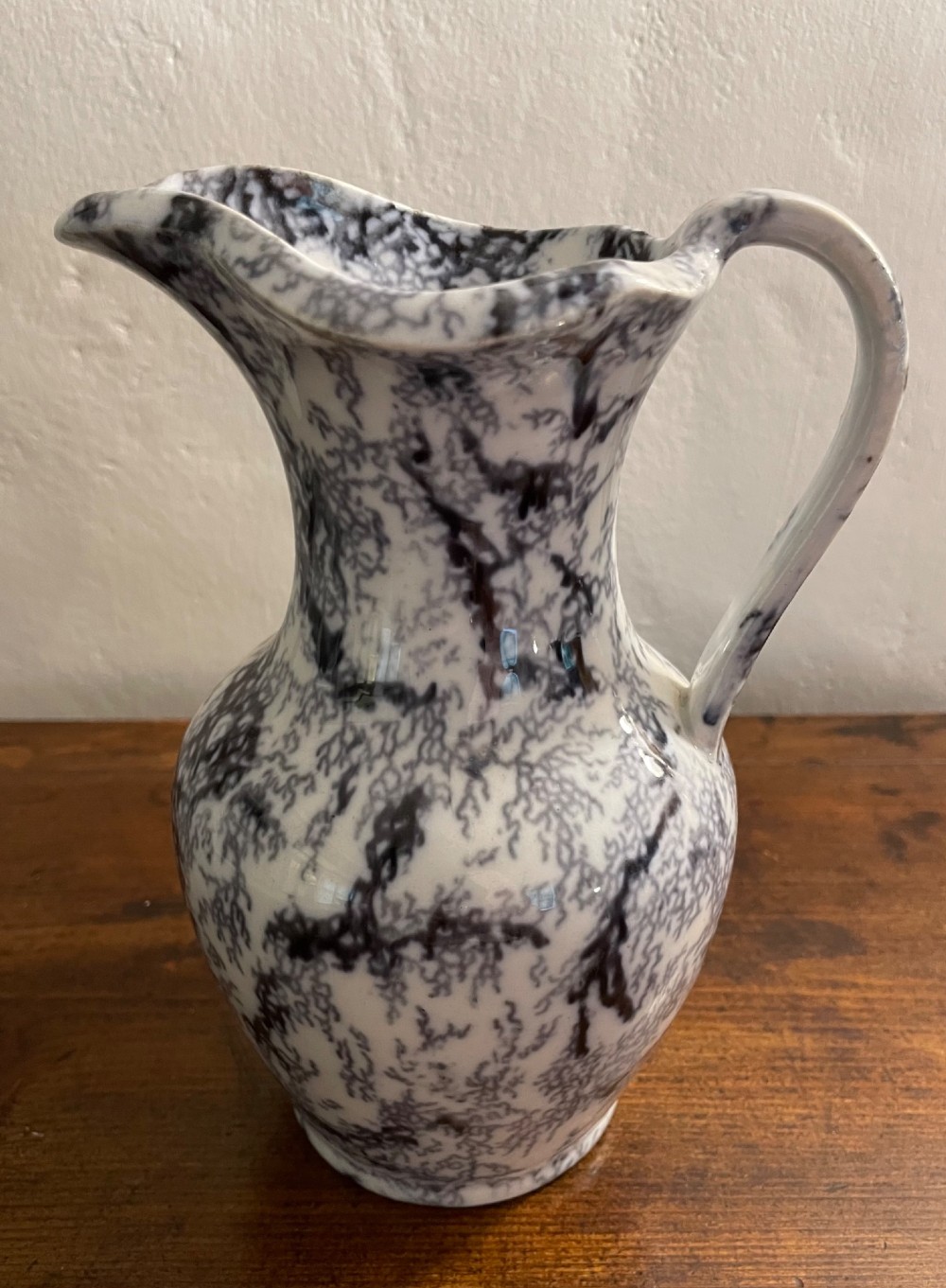 An early nineteenth-century Staffordshire flow blue ceramic wash set comprising a flared jug and matching wide wash basin with a mottled blue pattern. View VI