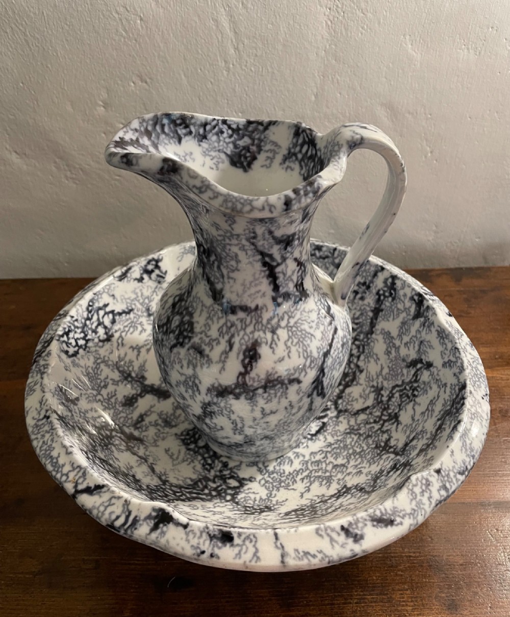 An early nineteenth-century Staffordshire flow blue ceramic wash set comprising a flared jug and matching wide wash basin with a mottled blue pattern. View XI