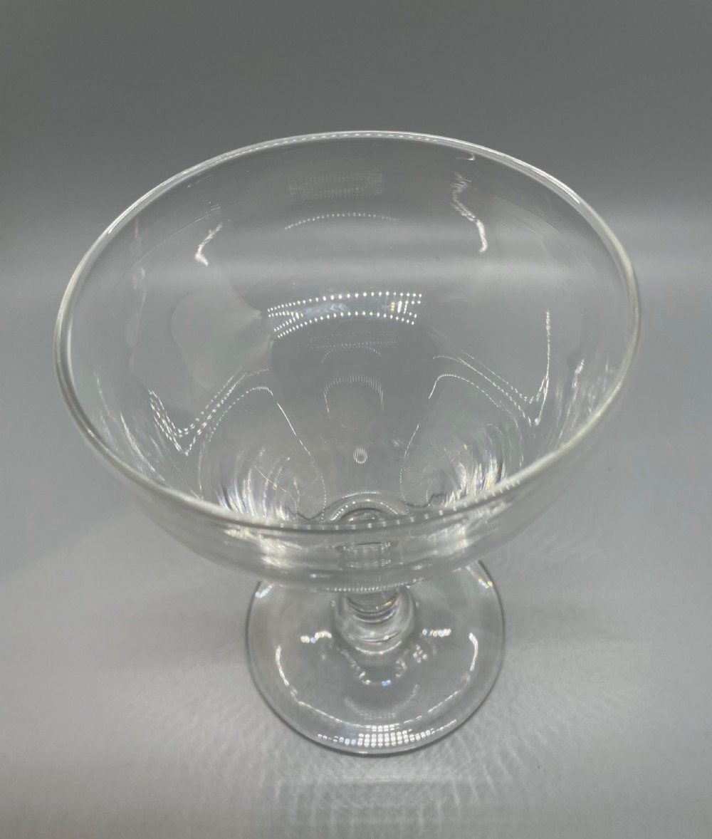 A matched pair of clear Georgian glass rummers featuring ogee-shaped bowls, short stems, and circular flat feet. View V