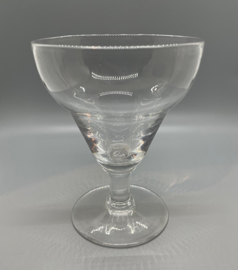 A matched pair of clear Georgian glass rummers featuring ogee-shaped bowls, short stems, and circular flat feet. View VI