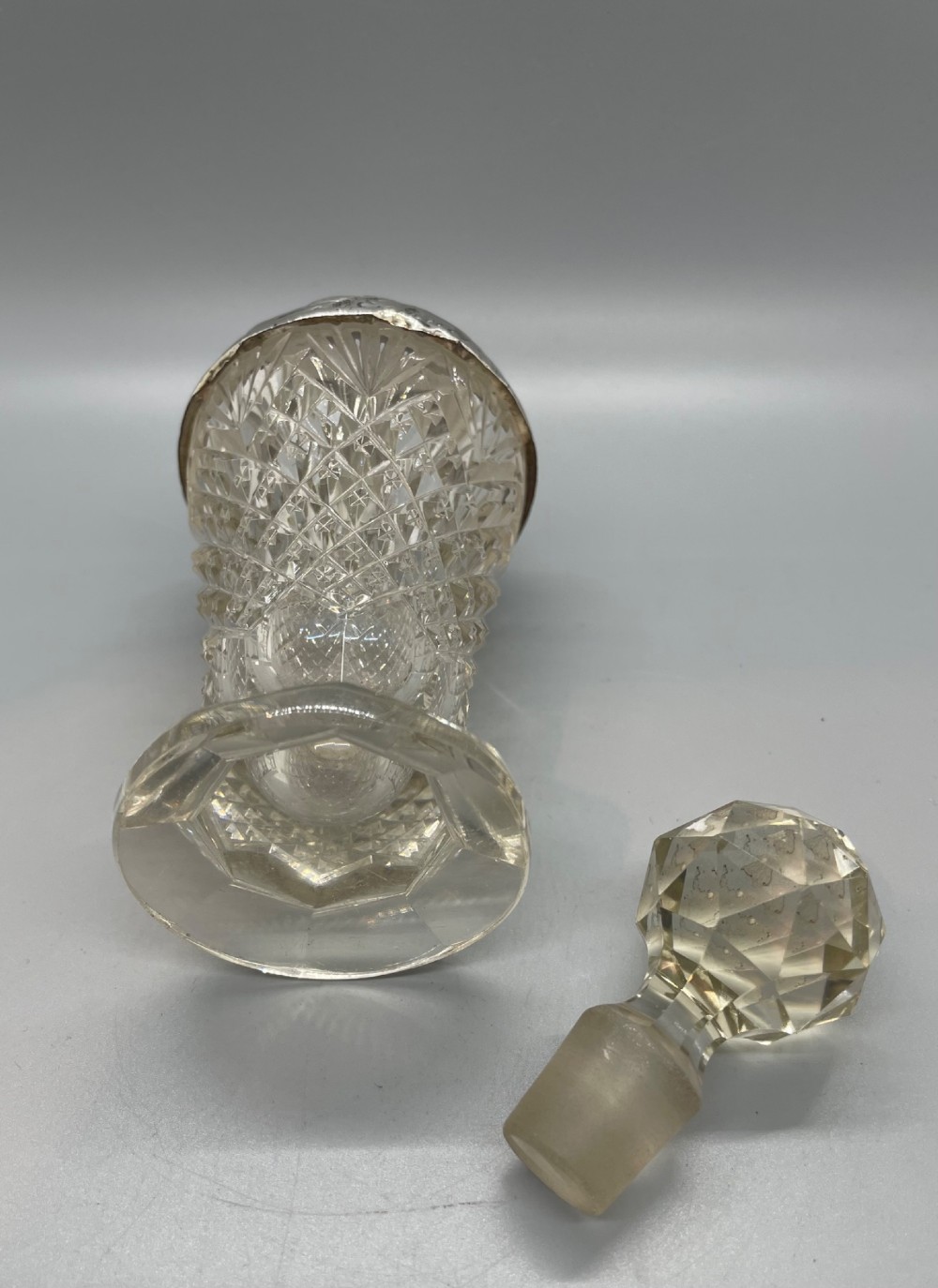 A pair of George V cut glass scent bottles featuring embossed sterling silver mounts and faceted glass stoppers. View XI