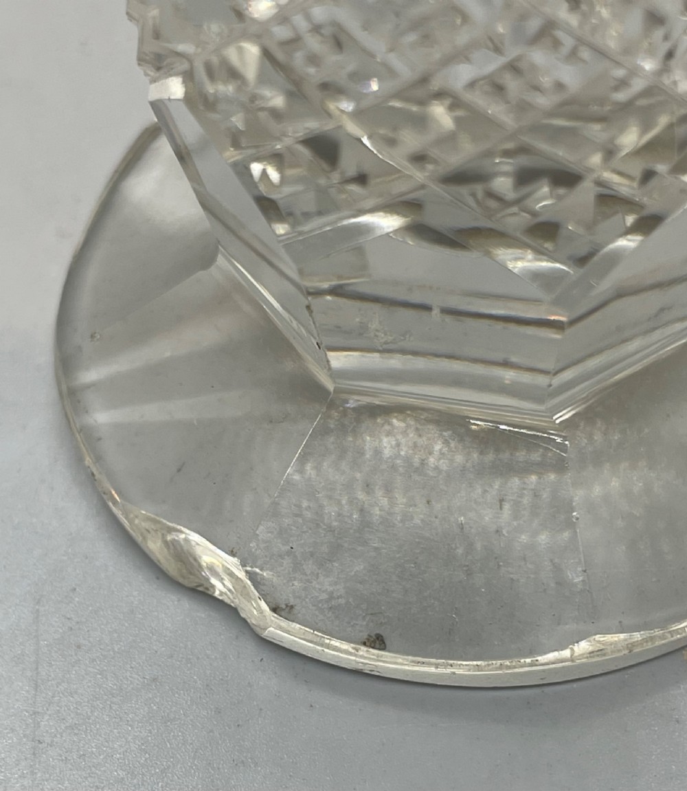 A pair of George V cut glass scent bottles featuring embossed sterling silver mounts and faceted glass stoppers. View XII