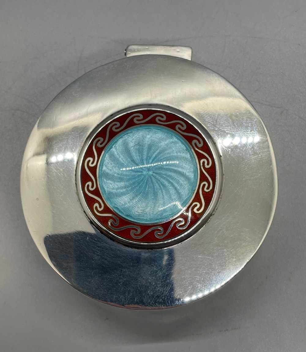 A circular sterling silver trinket box featuring a central light blue guilloche enamel medallion encircled by a red enamel border. View III