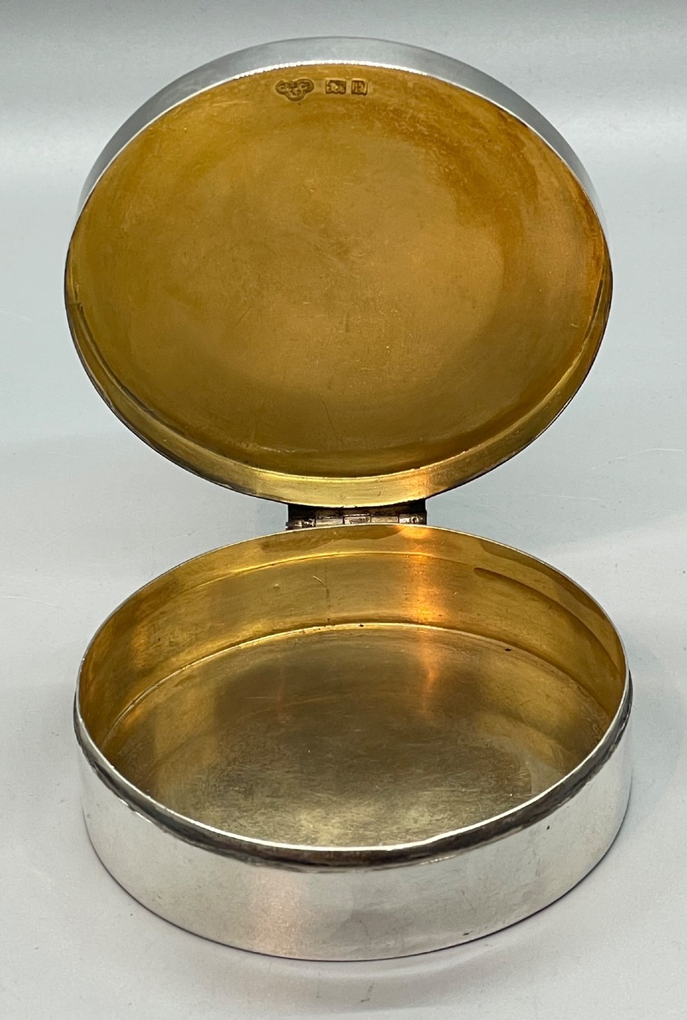 A circular sterling silver trinket box featuring a central light blue guilloche enamel medallion encircled by a red enamel border. View VIII