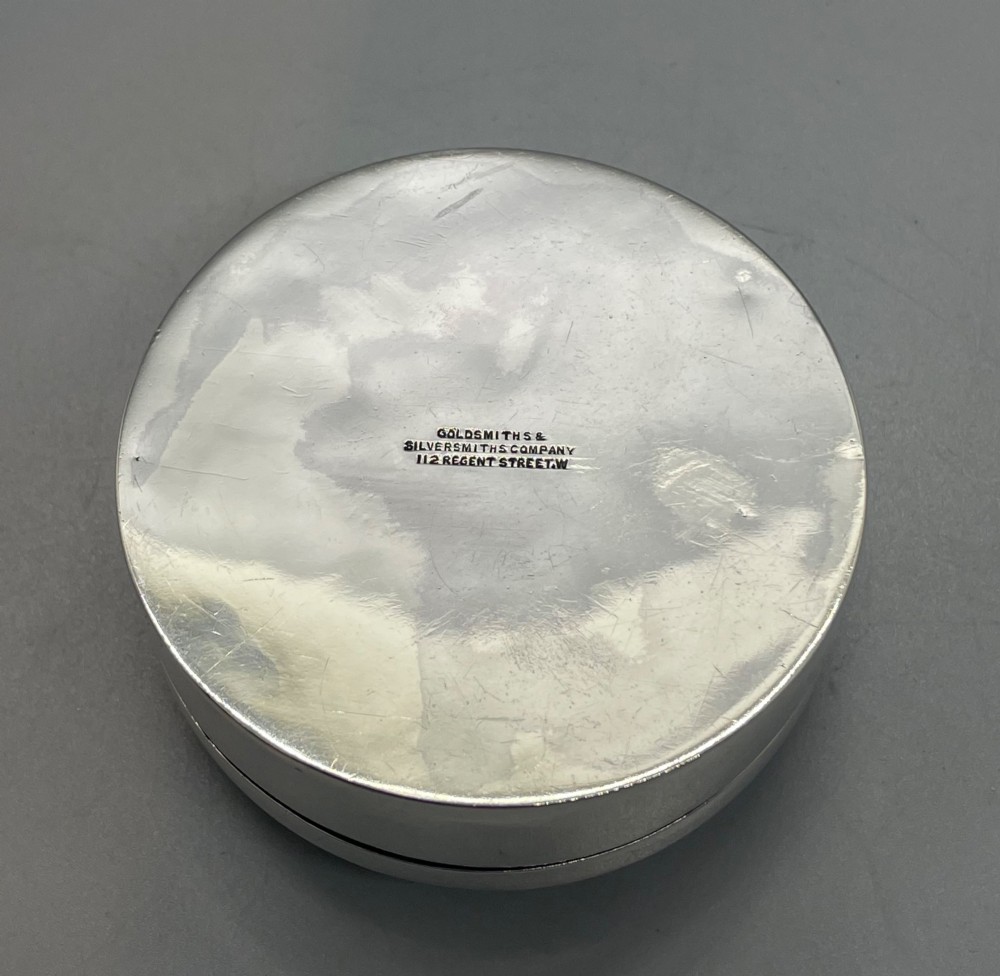 A circular sterling silver trinket box featuring a central light blue guilloche enamel medallion encircled by a red enamel border. View XII