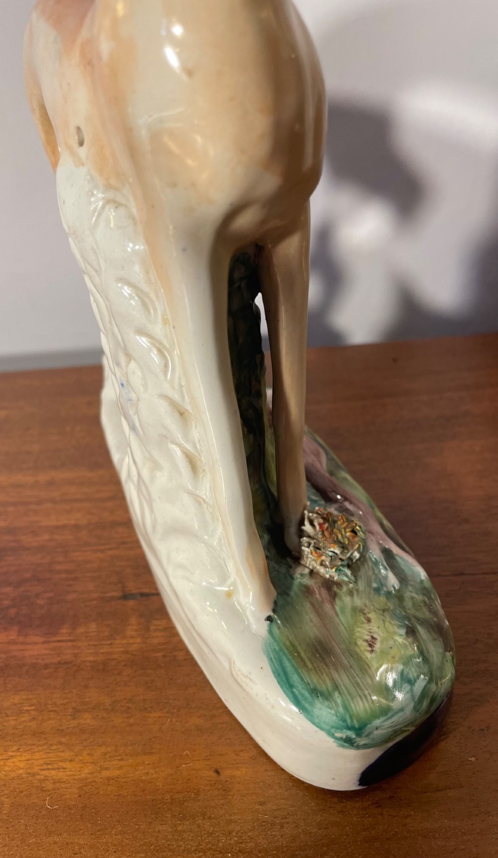 An antique Staffordshire earthenware figure depicting a standing tan hound with a crouching hare on a green and blue glazed base. View VII