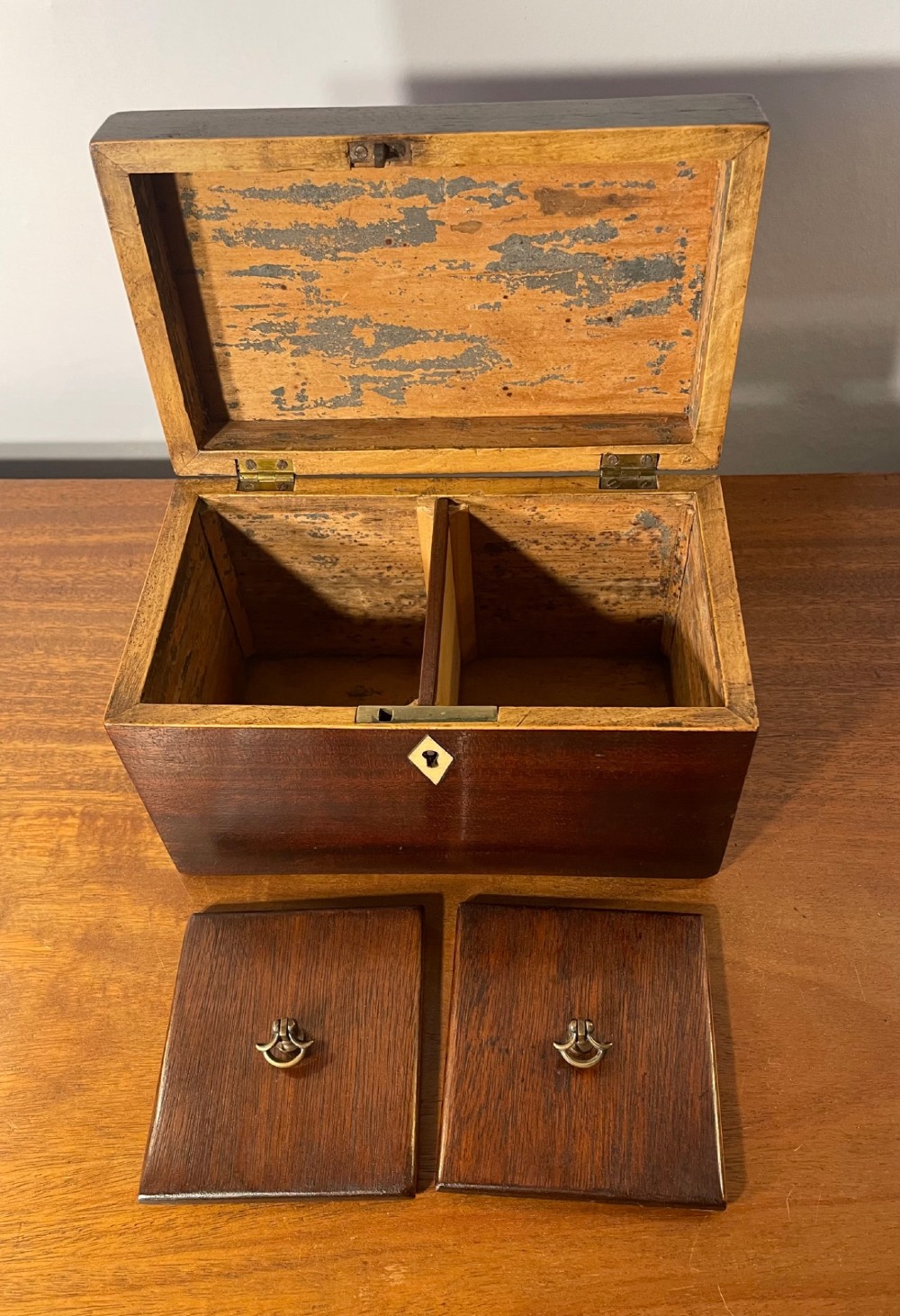 A rectangular Georgian dark mahogany tea caddy featuring delicate boxwood edge stringing and a diamond-shaped bone escutcheon on the front panel. View VII