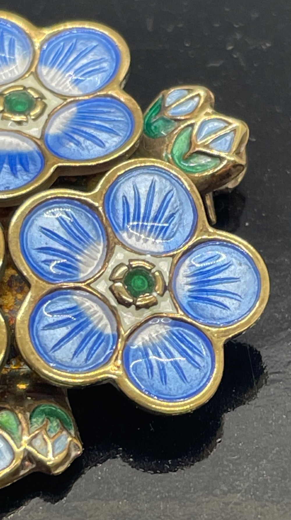A David Andersen silver gilt brooch featuring three blue and white enamelled forget-me-not flowers with green centres and leaves. View V