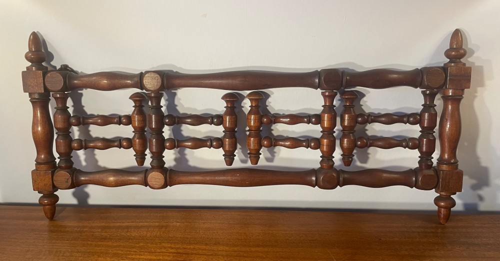 An Edwardian turned mahogany wall-mounted coat rack featuring horizontal spindle rails, four turned pegs, and decorative finials. View VII
