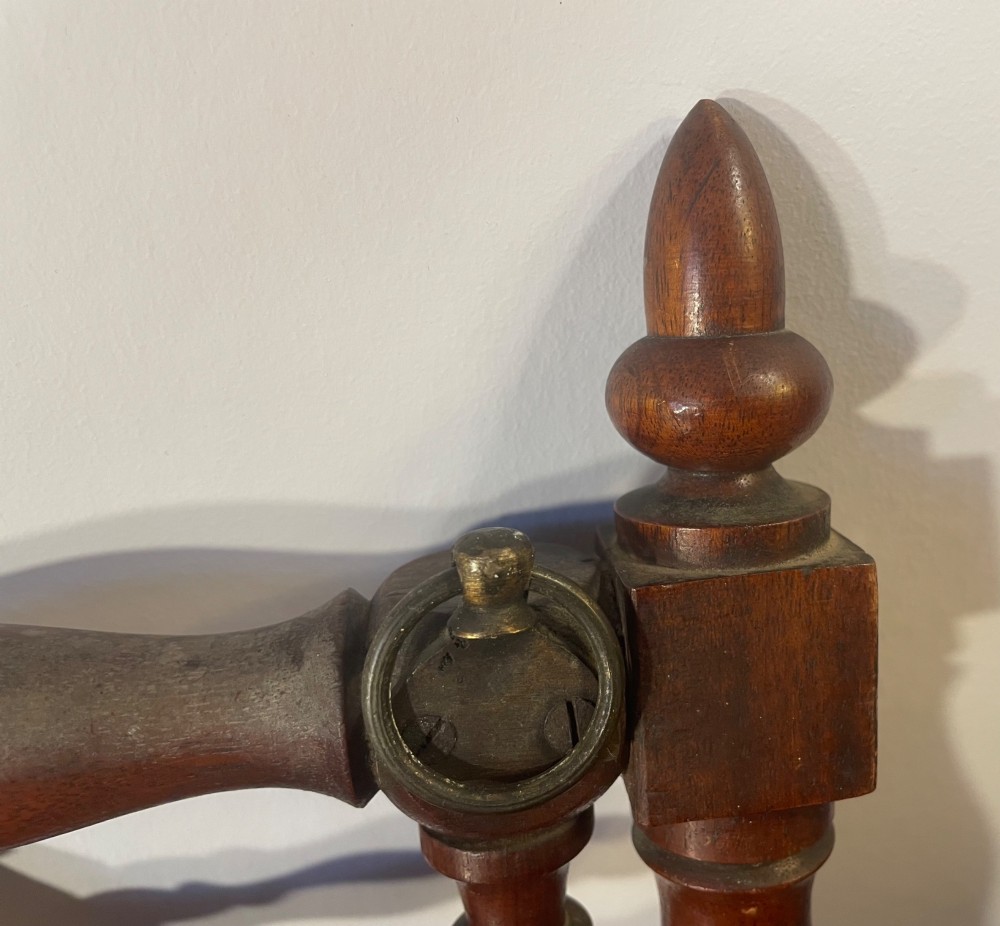 An Edwardian turned mahogany wall-mounted coat rack featuring horizontal spindle rails, four turned pegs, and decorative finials. View VIII