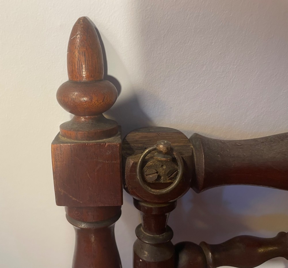 An Edwardian turned mahogany wall-mounted coat rack featuring horizontal spindle rails, four turned pegs, and decorative finials. View IX
