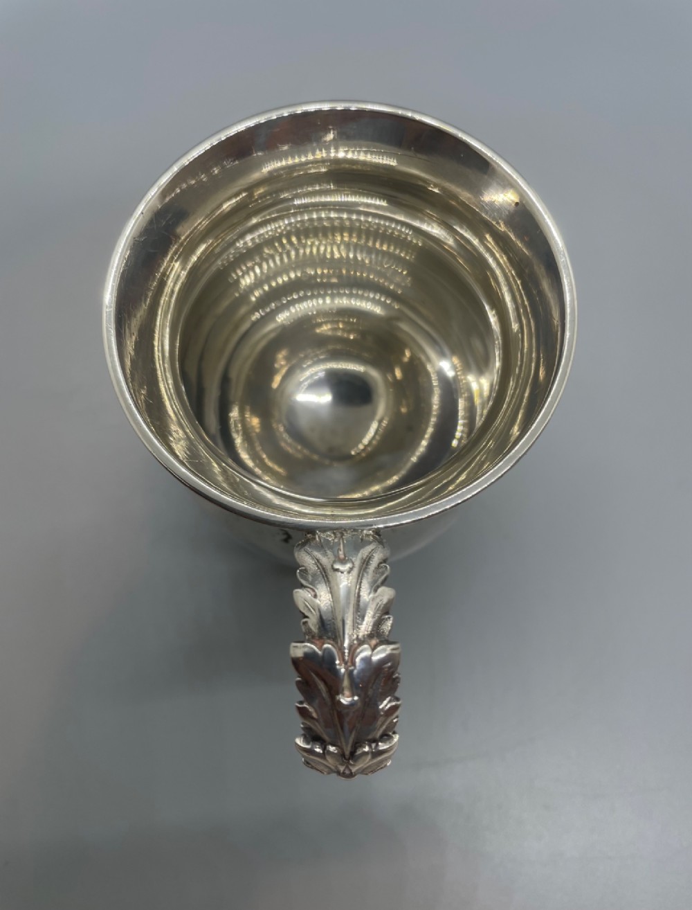 A George IV sterling silver baluster mug featuring a reeded collar, decorative acanthus leaf handle, and a stepped circular pedestal base. View VI