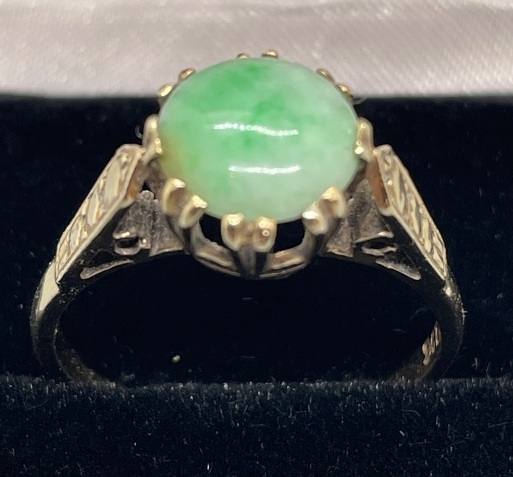 A vintage 9ct yellow gold ring featuring a polished round green jade cabochon in a multi-claw setting with geometric engraved shoulders. View IV