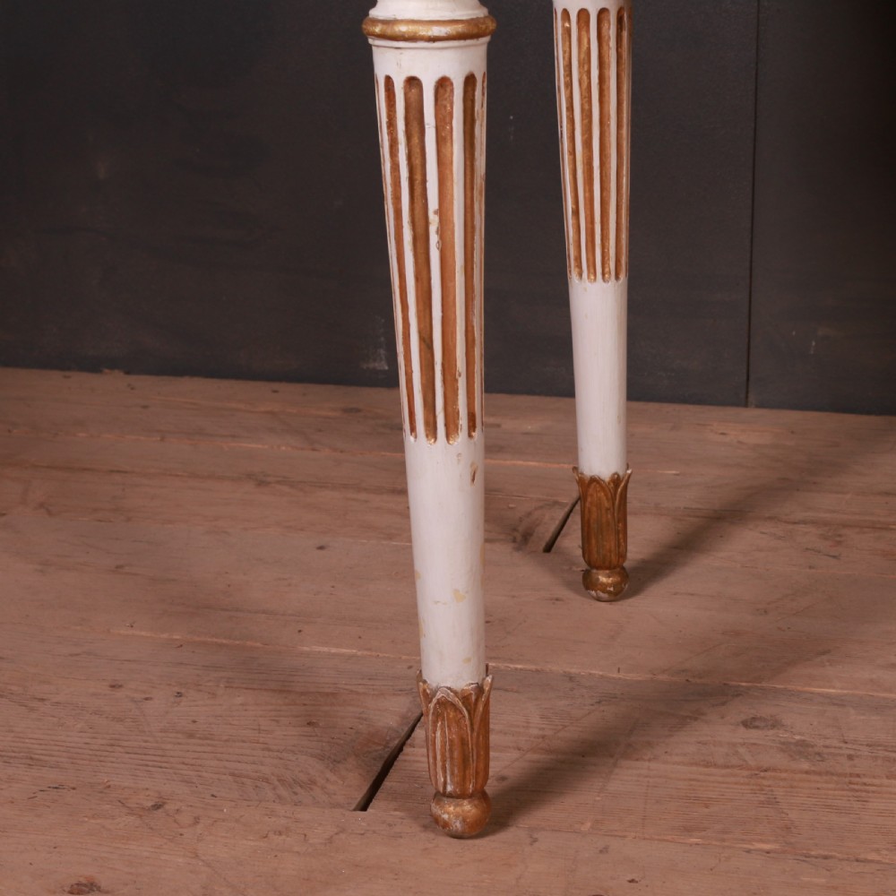 A Gustavian off-white painted writing table with gilded drapery swags, carved rosette blocks, and fluted legs. View IV