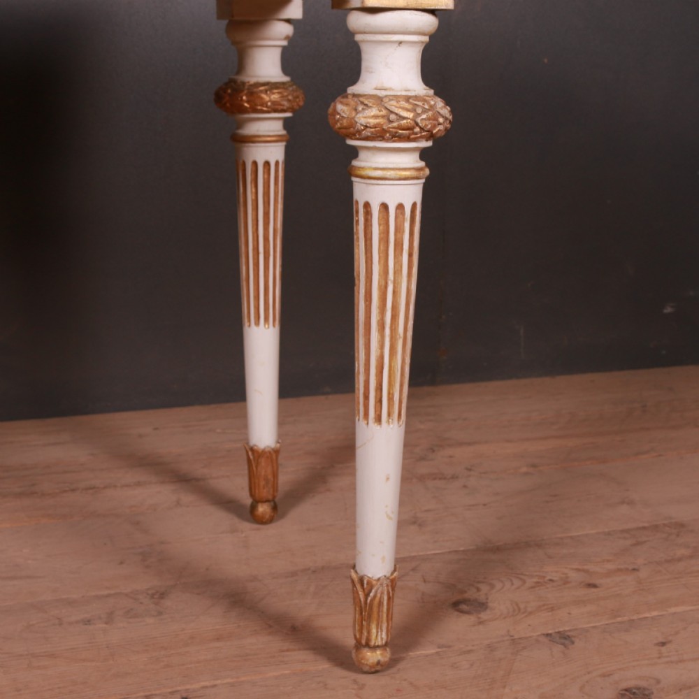 A Gustavian off-white painted writing table with gilded drapery swags, carved rosette blocks, and fluted legs. View V