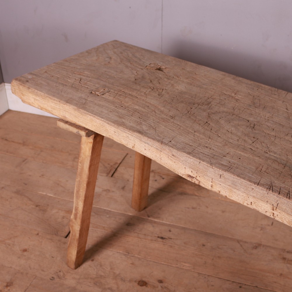 A long, narrow rustic French trestle table constructed from scrubbed sycamore and elm with four splayed legs. View III
