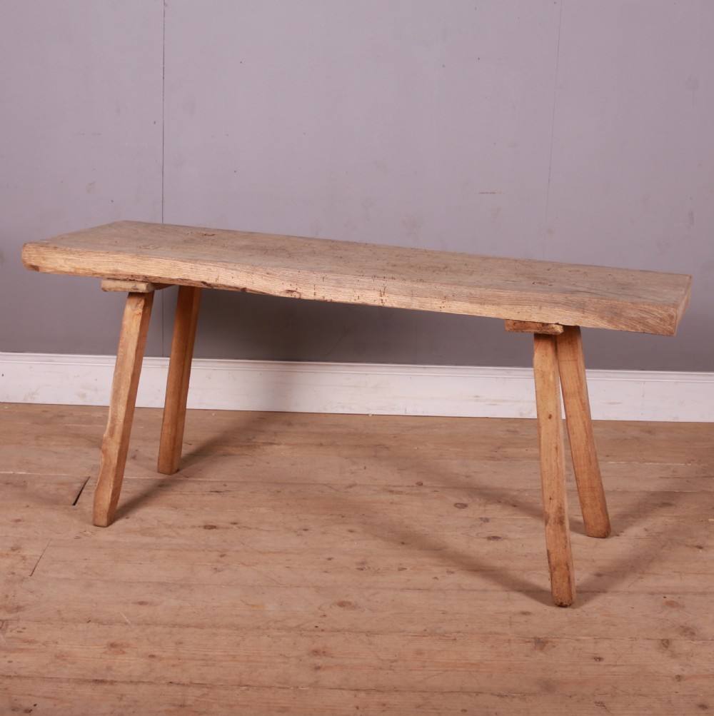 A long, narrow rustic French trestle table constructed from scrubbed sycamore and elm with four splayed legs. View V