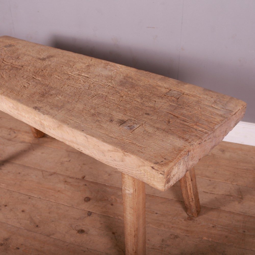A rustic scrubbed sycamore and elm trestle table with a thick rectangular top and four splayed wooden legs. View II