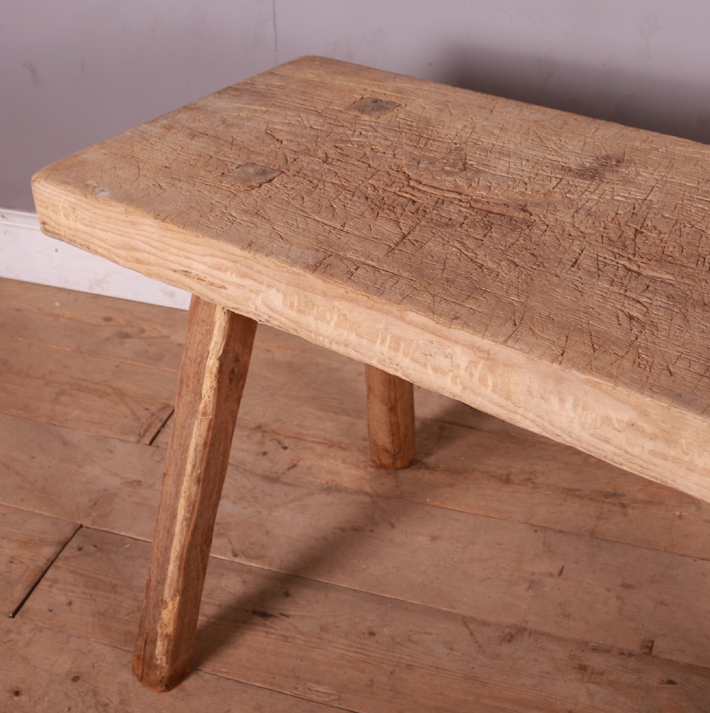 A rustic scrubbed sycamore and elm trestle table with a thick rectangular top and four splayed wooden legs. View IV