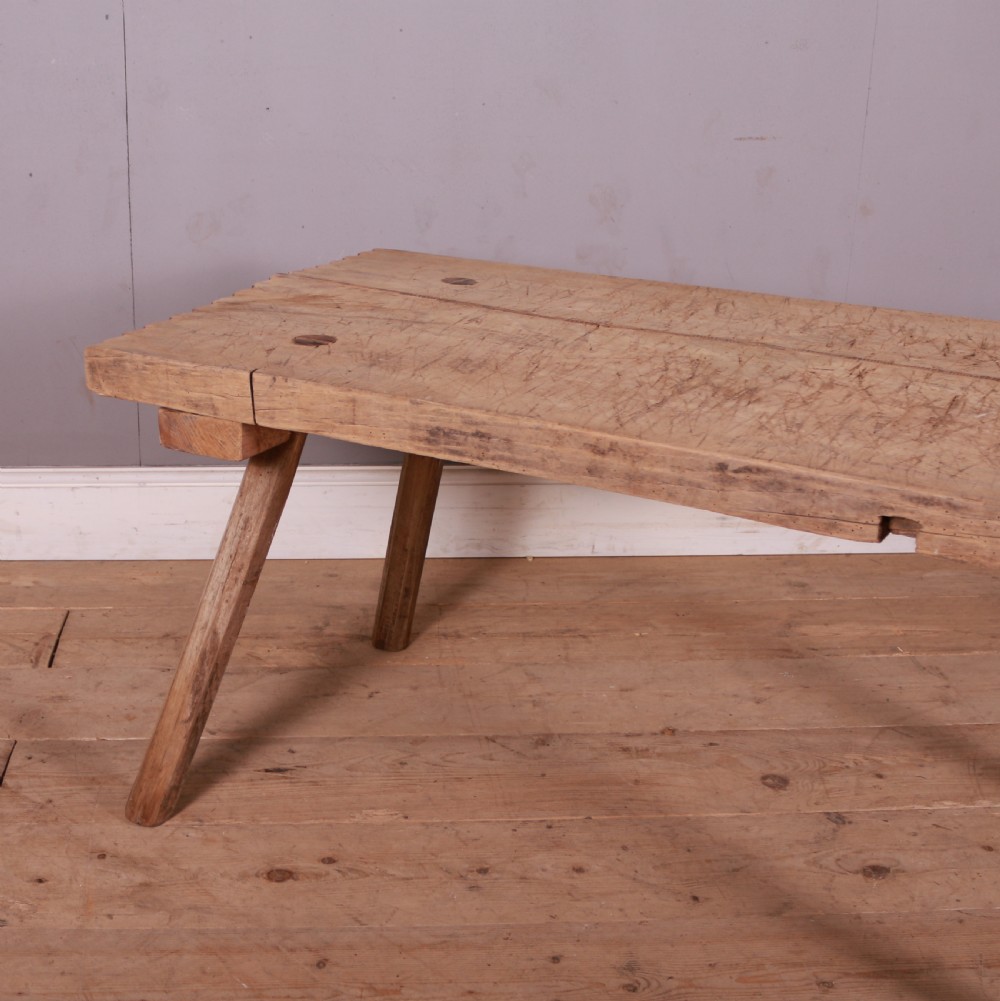 A rustic French scrubbed sycamore and elm trestle table featuring a thick plank top with visible peg construction and splayed wooden legs. View II