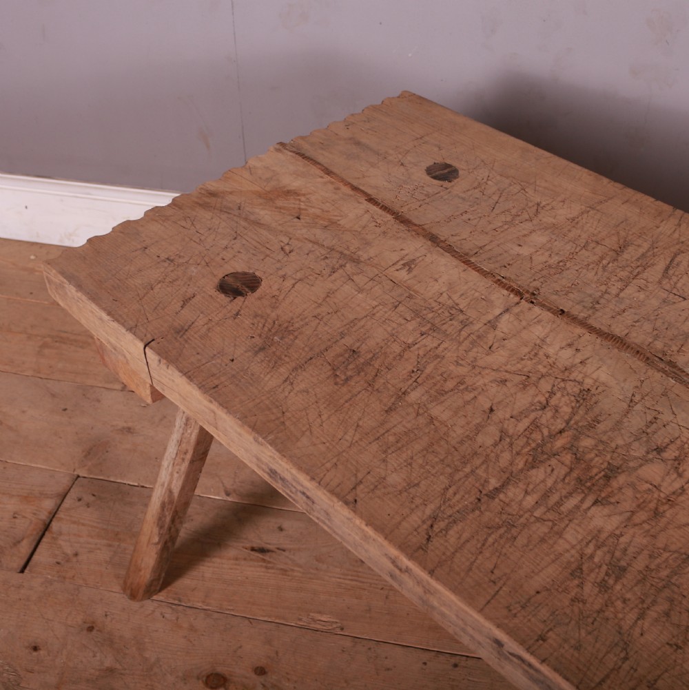 A rustic French scrubbed sycamore and elm trestle table featuring a thick plank top with visible peg construction and splayed wooden legs. View IV
