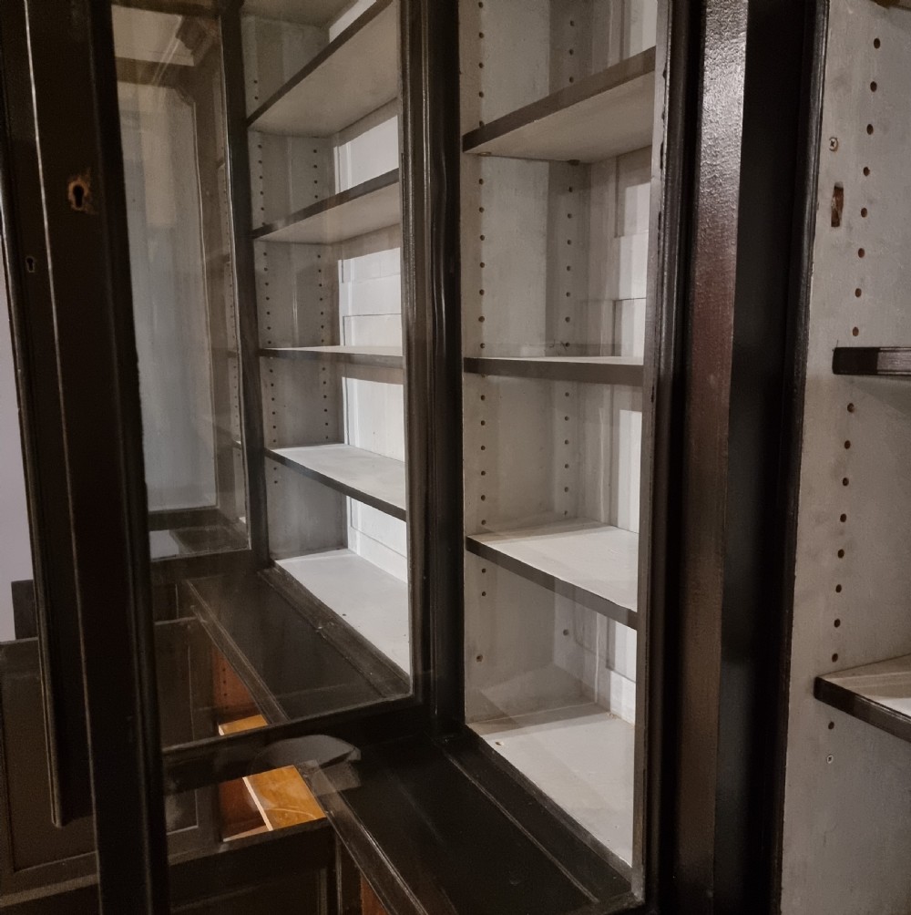 A large dark ebonised wooden breakfront library bookcase featuring glazed upper doors and panelled lower cupboard doors. View X
