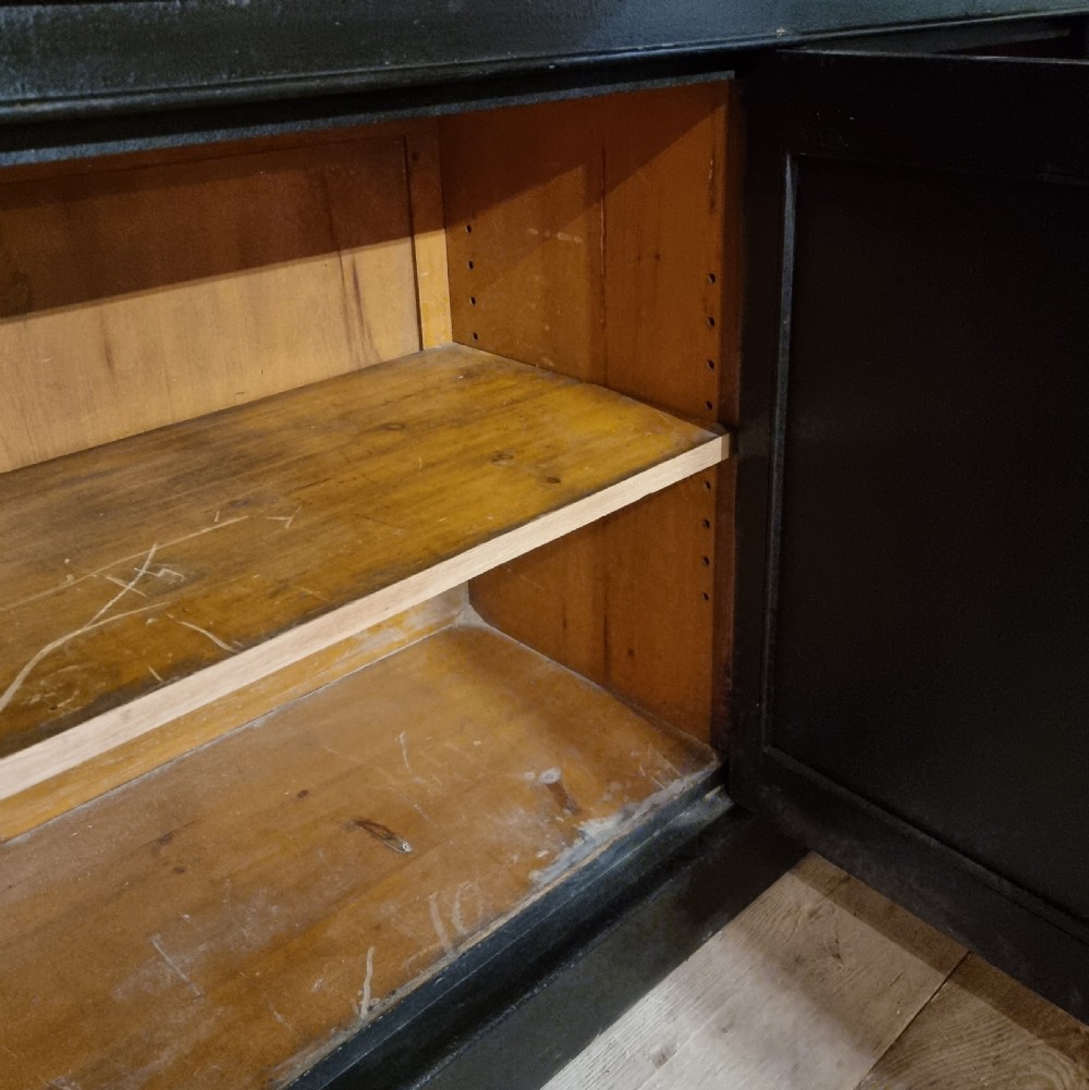 A large dark ebonised wooden breakfront library bookcase featuring glazed upper doors and panelled lower cupboard doors. View XI