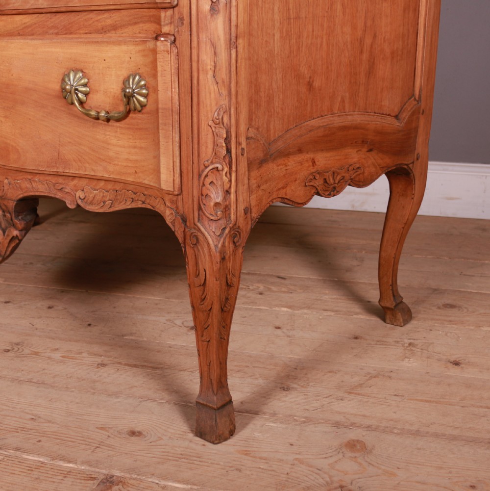 An eighteenth-century French serpentine timber chest of drawers featuring two drawer fronts, brass handles, and a centrally carved shell apron. View III