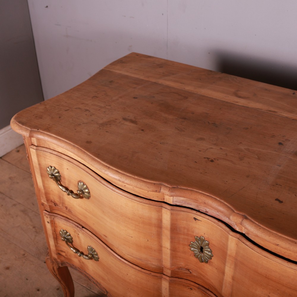 An eighteenth-century French serpentine timber chest of drawers featuring two drawer fronts, brass handles, and a centrally carved shell apron. View VIII