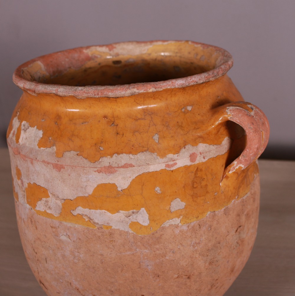 An antique French terracotta confit pot featuring an aged mustard-yellow glaze on the upper rim and a single side loop handle. View II