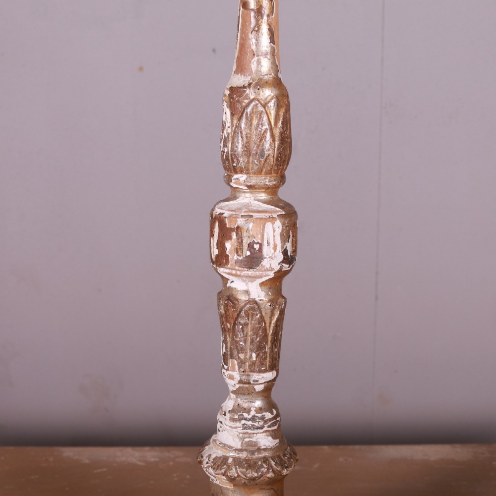 A tall hand-carved Italian giltwood candlestick featuring a turned shaft, leaf details, weathered gold finish over gesso, and a tripod base. View III