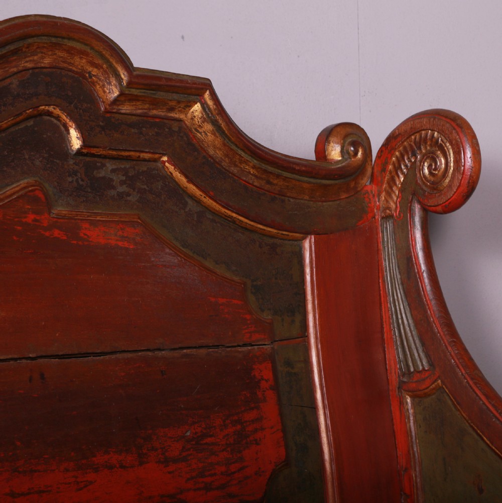 An 18th-century Dutch painted wooden bench with a high serpentine back, scrolled arms, and red and dark green polychrome decoration. View XII
