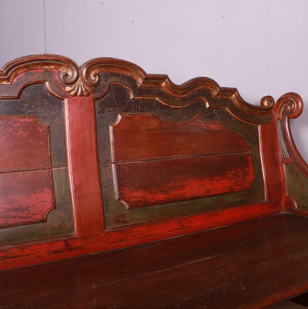 An 18th-century Dutch painted wooden bench with a high serpentine back, scrolled arms, and red and dark green polychrome decoration. View XIII