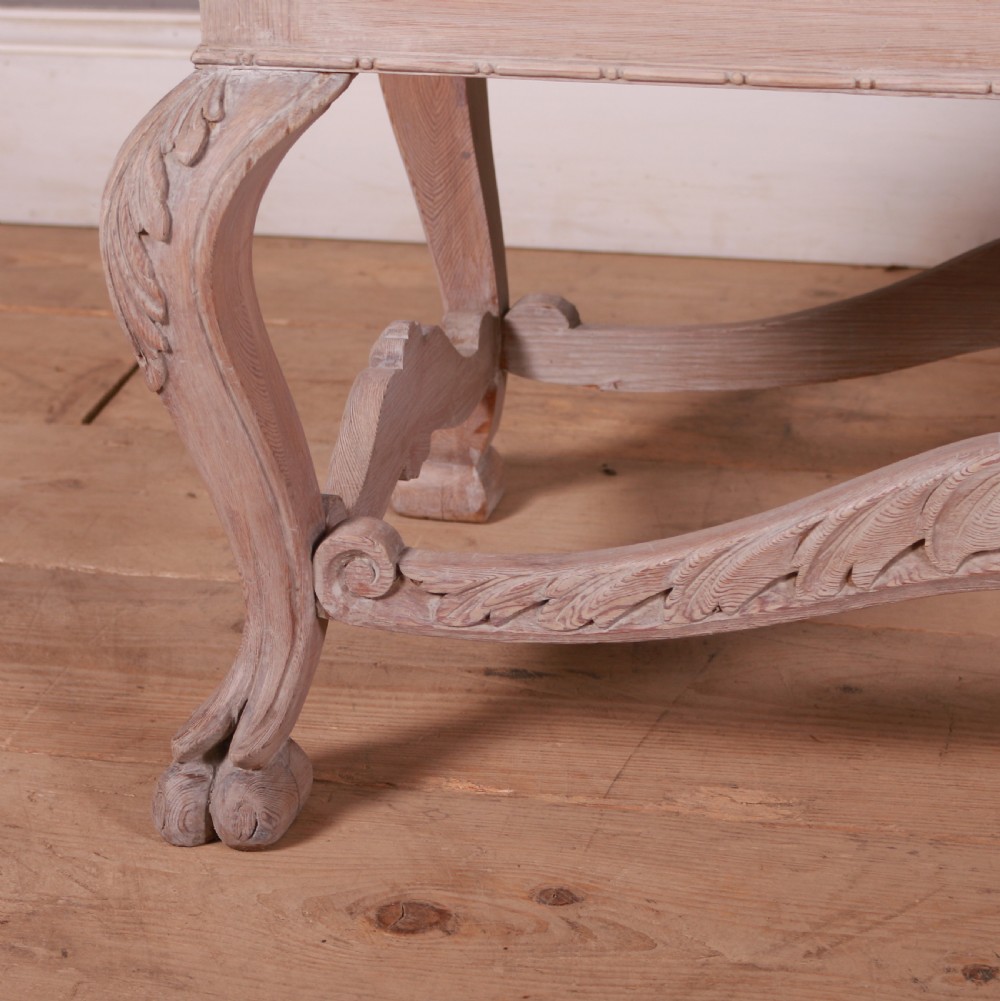 A low rectangular Dutch bleached pine coffee table featuring acanthus leaf carvings, ornate scrolled stretchers, claw feet, and an inset glass top. View V