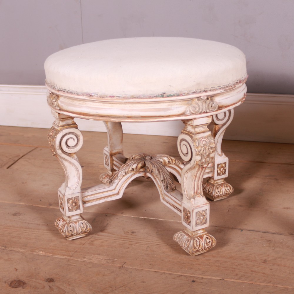 A pair of circular Swedish stools featuring cream and gold painted frames, scroll legs, arched stretchers, and off-white upholstered seats. View II
