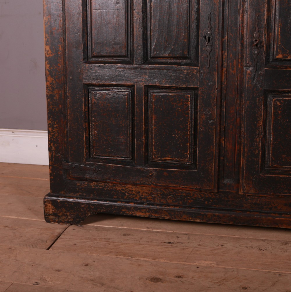 An 18th-century French dark oak food cupboard featuring turned spindle upper door panels and solid wooden lower door panels. View II