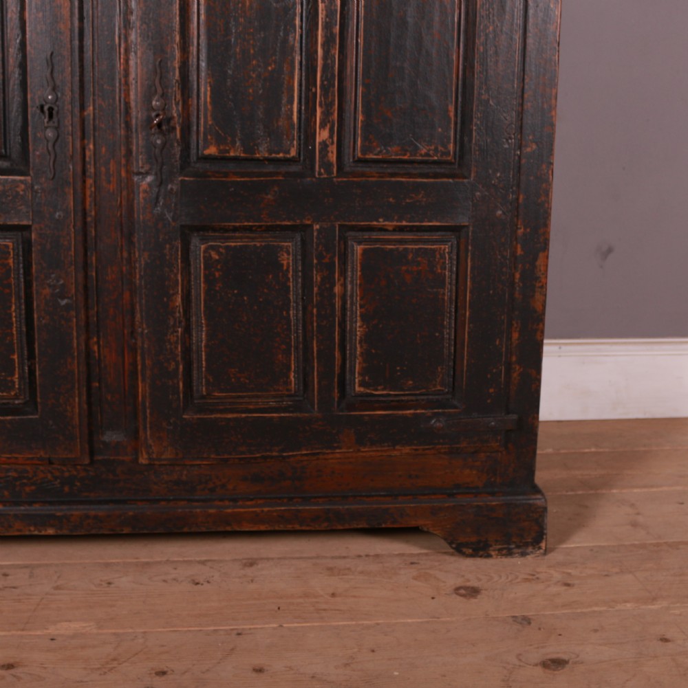 An 18th-century French dark oak food cupboard featuring turned spindle upper door panels and solid wooden lower door panels. View III