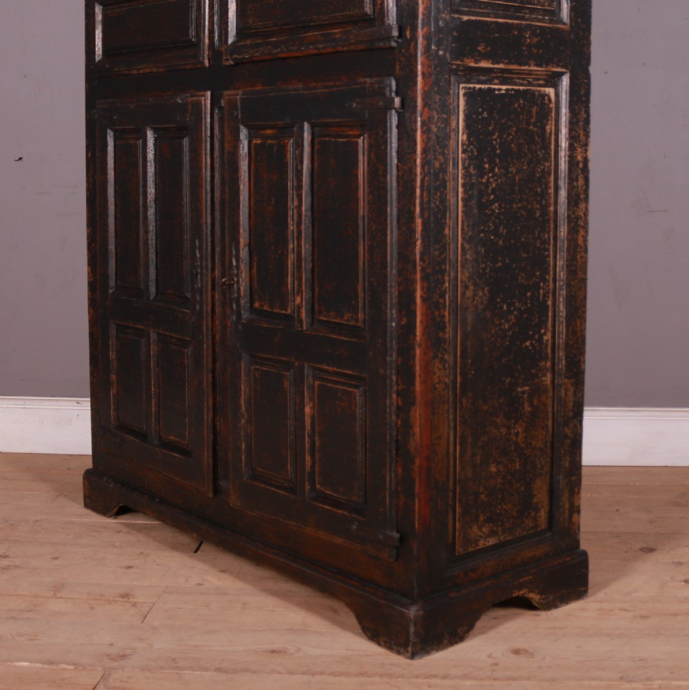 An 18th-century French dark oak food cupboard featuring turned spindle upper door panels and solid wooden lower door panels. View XII